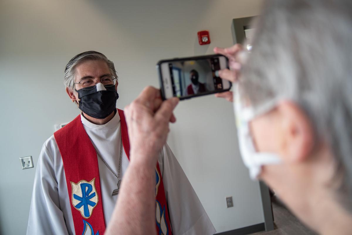 Barbara Hackbart takes a photo of Pastor Michael Schmidt Sr.Õs face mask following the service of dedication on Sunday. ÒIt is such an honor and a blessing to be with people, even with masks on. It is a huge blessing to the Saints of God together singing his praises,Ó said Pastor Michael Schmidt Sr.