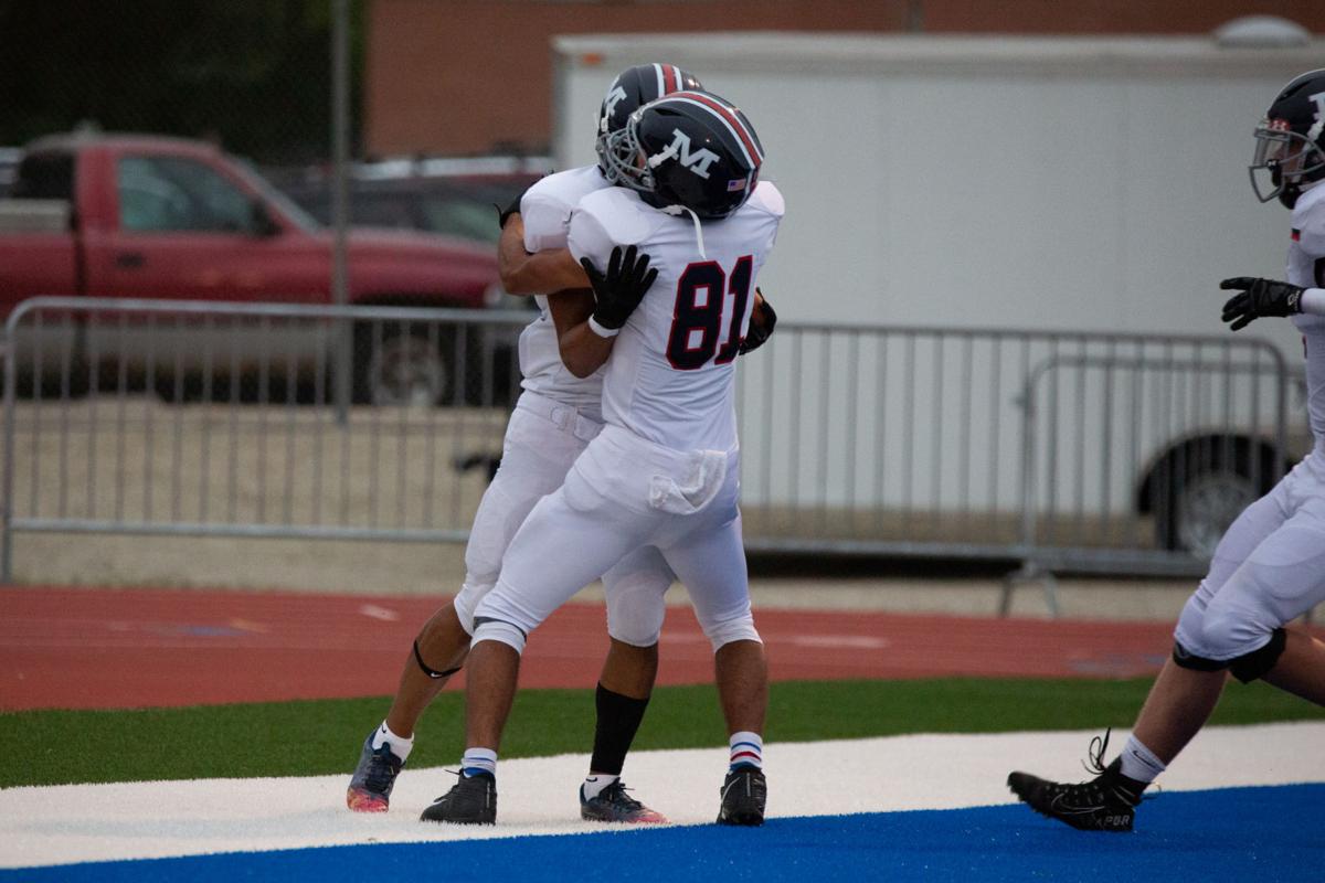 Running back Vincent Smith, junior, is hugged by Tate Brown, junior. Manhattan High Indians went head to head against the Junction City Bluejays on Friday night at Al Simpler Stadium with a final score of Junction City 36, Manhattan 29.