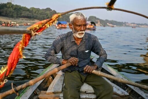 Boatman Chhote Lal Nishad rows his boat across the river Yamuna in Prayagraj