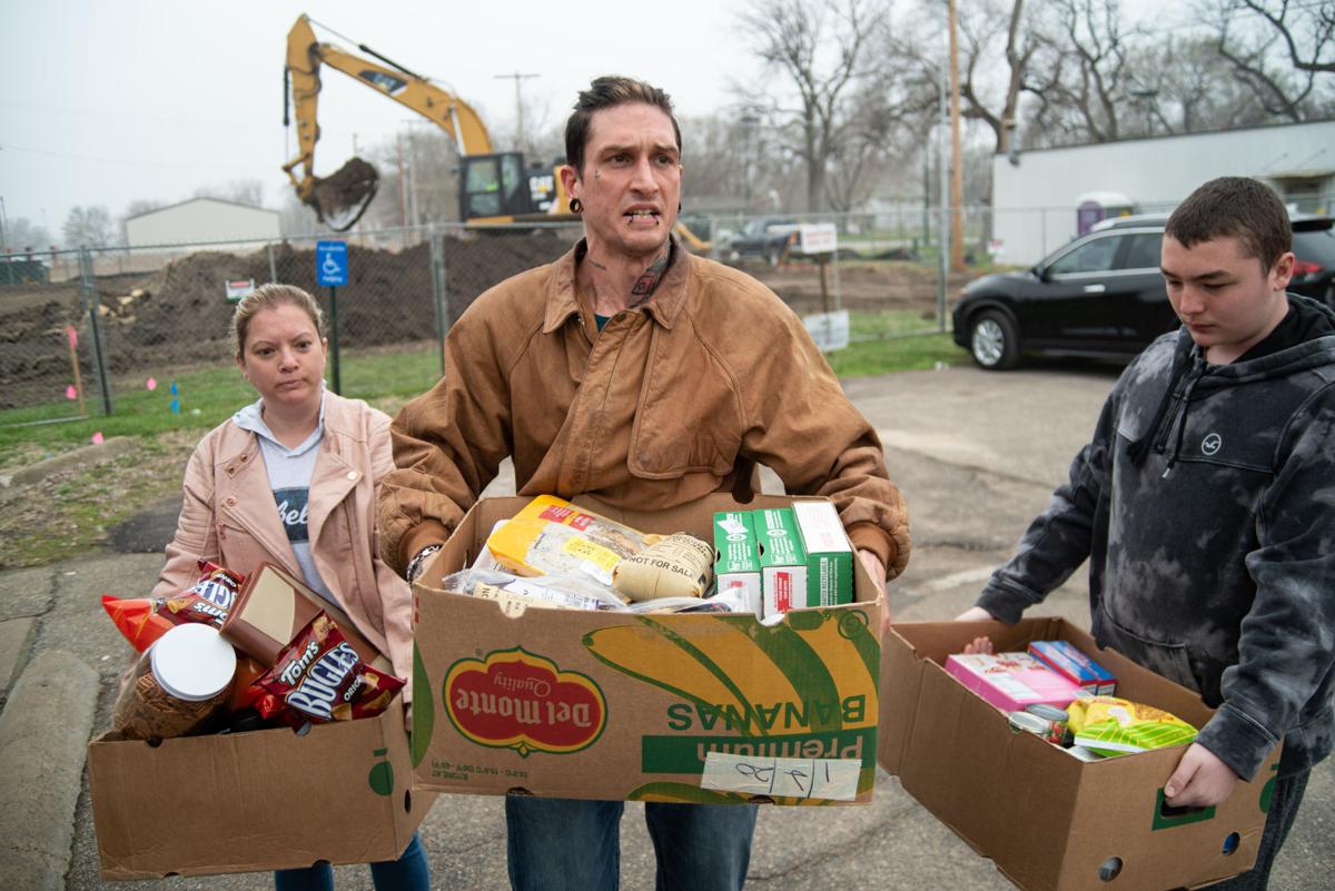 From left, Jackie Smith, Eric Lubrano and James Mullins carry their food from the Flint Hills Breadbasket to the bus stop on Friday. Smith and Lubrano moved back to Manhattan from West Virginia in February and got jobs at McDonaldÕs and Early Edition. Due to the coronavirus pandemic, Smith and Lubrano have been laid off of their jobs for the time being.