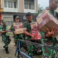 Tentara Indonesia yang pergi ke pulau dekat gunung berapi Gunung Ruang memuat kapal dengan perbekalan makanan.  Nasional