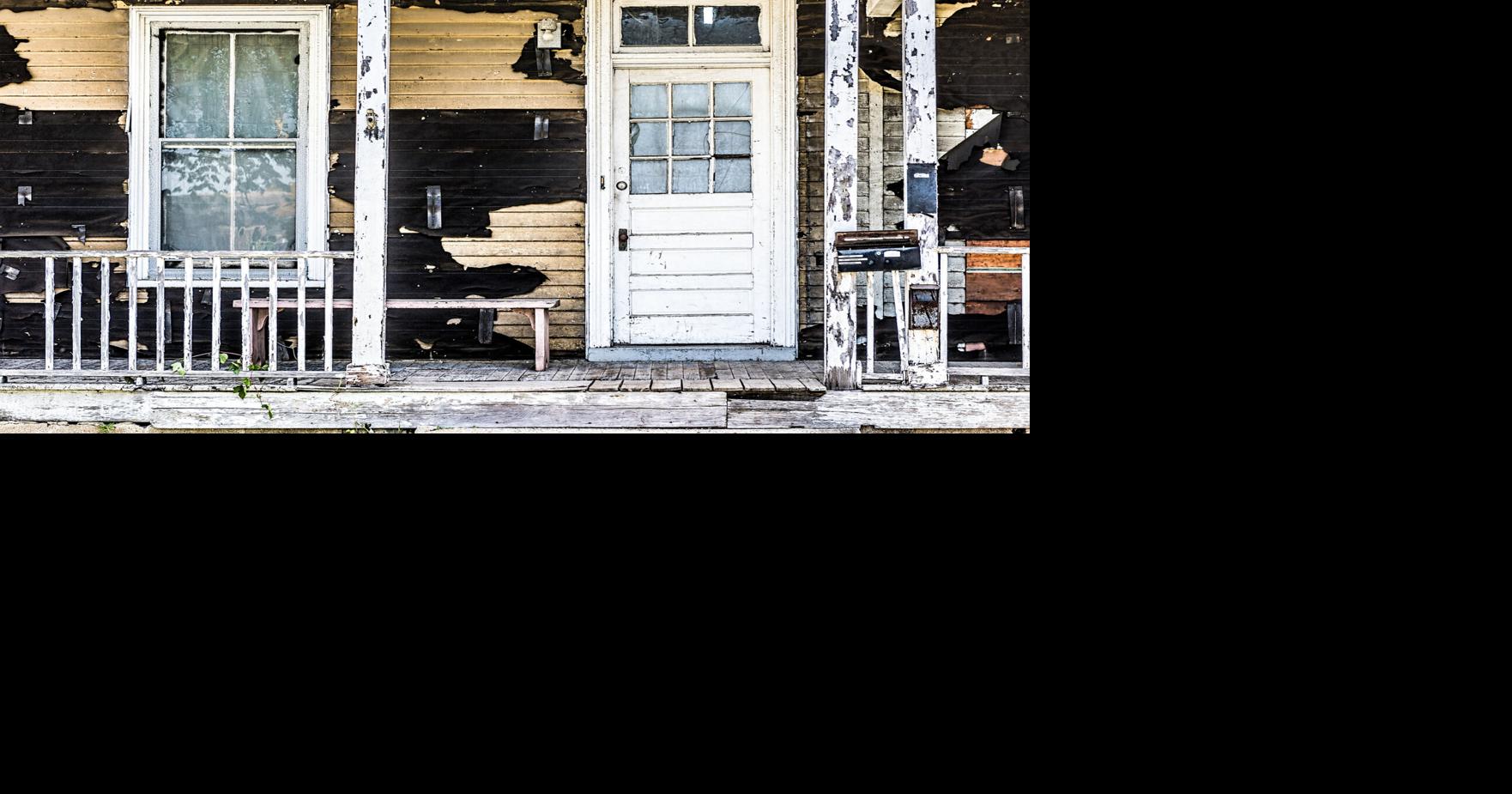 Old abandoned weathered wooden house with porch entrance, peeling paint ...