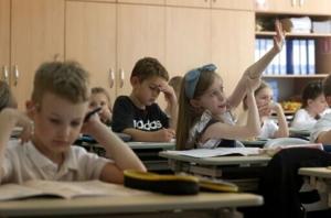 Uma aluna da primeira série levanta a mão durante uma aula na escola secundária nº 61 em Kiev, em 24 de maio de 2024.