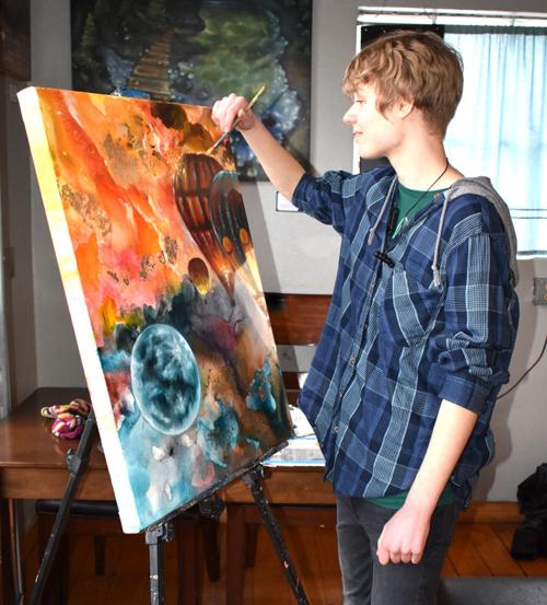 Artist paints at Gathering Grounds