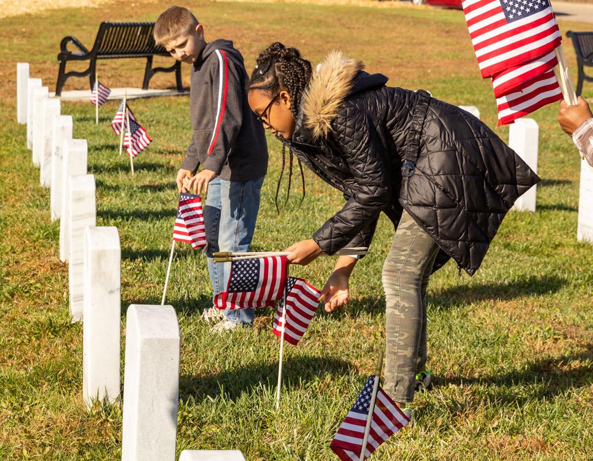 Paying respect: Volunteers place flags at Veteran’s cemetery