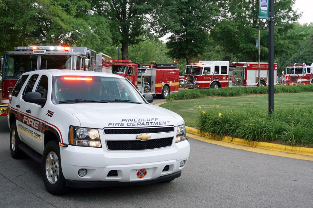 Fire department vehicles parade around FirstHealth Moore Regional