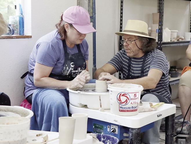 Simon Leach assists Shaunalynn Santee with her cylinder in the first day of his local workshop.