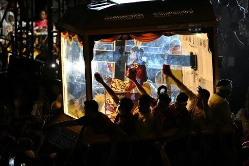 Philippine Catholic devotees using towels wipe the glass of the carriage carrying the image of Jesus Nazareno, also known as Jesus the Nazarene, during the annual religious procession in Manila