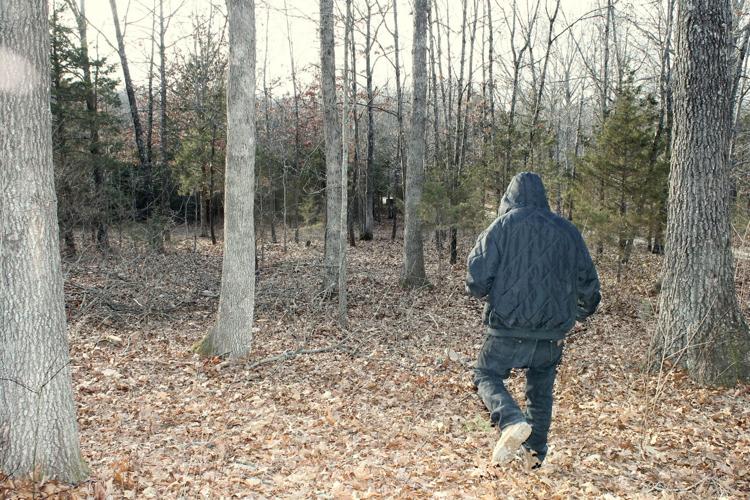 Aaron walking through the woods by his home