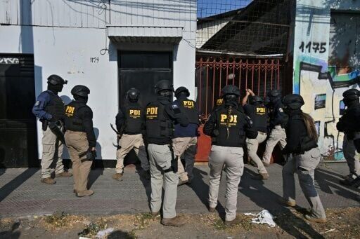 Members of Chile's Investigative Police (PDI) raid a house during an anti-drug operation in Santiago, on December 11, 2025