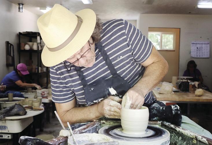 Simon Leach throws a small bowl to demonstrate the Leach treadle wheel.