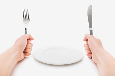 empty plate with fork and knife and hands
