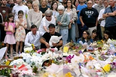 Family members of victims react as they stand with other mourners near tributes at the Bondi Pavilion