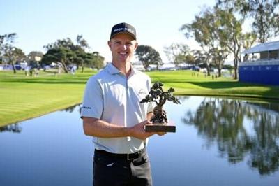 Justin Rose of England poses with the trophy after winning the PGA Farmers Insurance Open