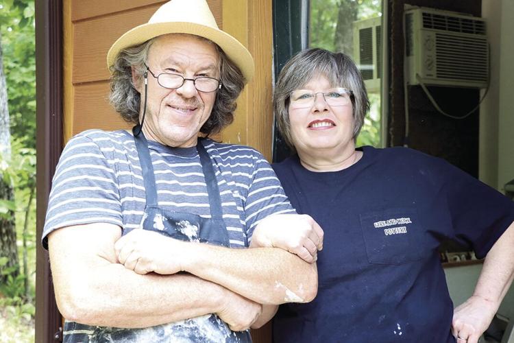 Simon Leach and Kerry Collins stand near the entrance to Fire and Muck Pottery.