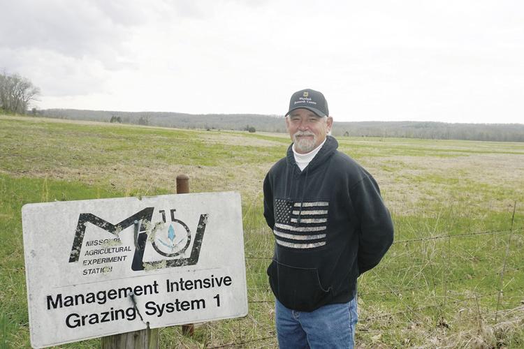 Brent Booker next to an old university sign