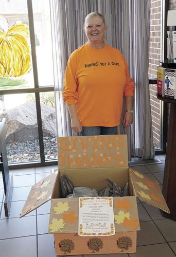 Librarian Glenda Wofford with the box for the library food drive