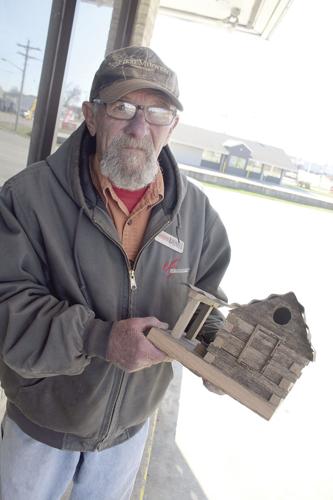 Larry Dallas holding one of his bird houses