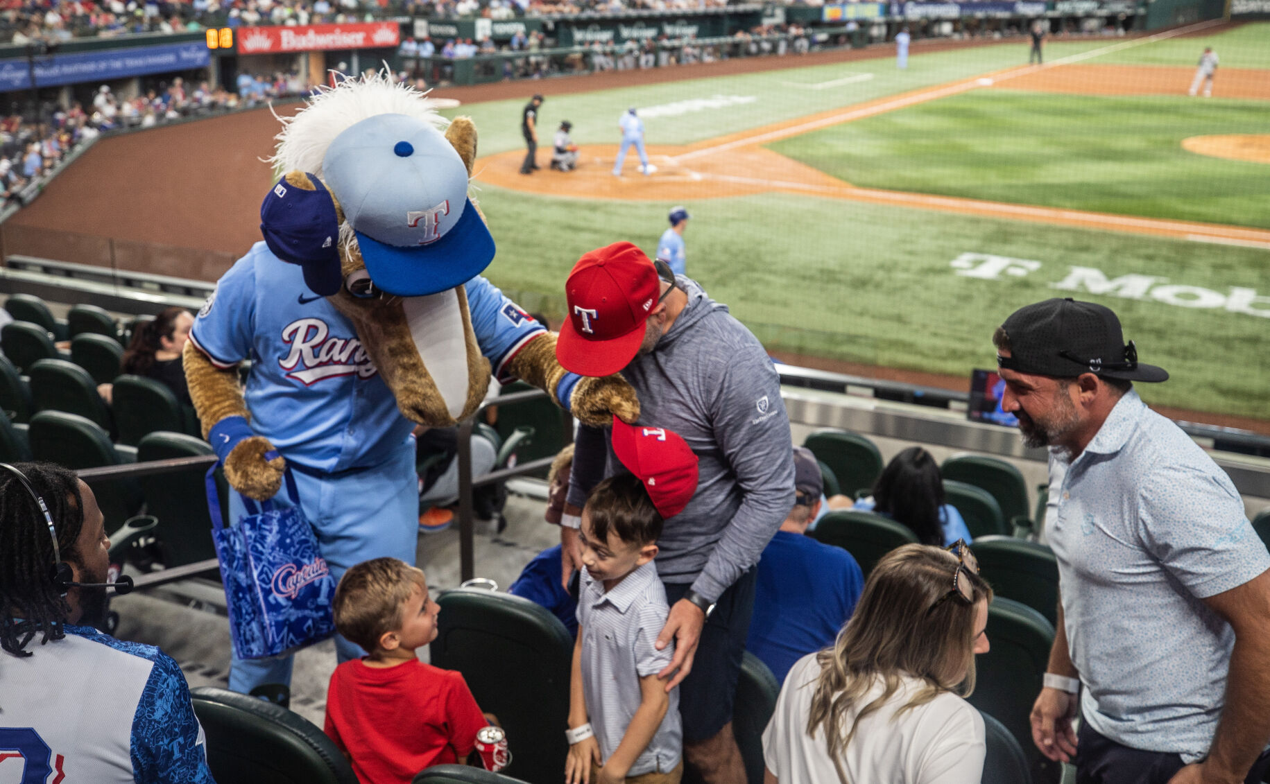 The Texas Rangersu2019 mascot, Captain, gives a hat to McKinney, Texas, resident Graham Moman, 7, during a game against the Cleveland Guardians on Aug. 24 at Globe Life Field.