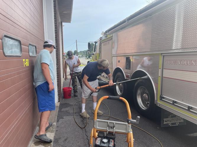 From left, Meredith Hose Co. volunteers Jake Sweeney, Grant Chase and DjJ Wright wash one of the company’s trucks after a recent call.