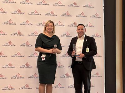 Magda Dexter, senior vice president of HR & Communication at Saint-Gobain North America, presents Patrick J. Sheehan, superintendent of Mid Valley School District, with the trophy and prize at the Saint-Gobain North America headquarters in Malvern.