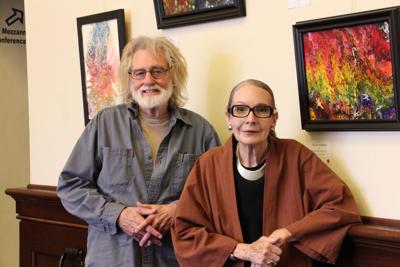 International artist Dennis Corrigan stands next to The Chamber Gallery director Ruthanne Jones, in front of art displayed at the gallery through July.