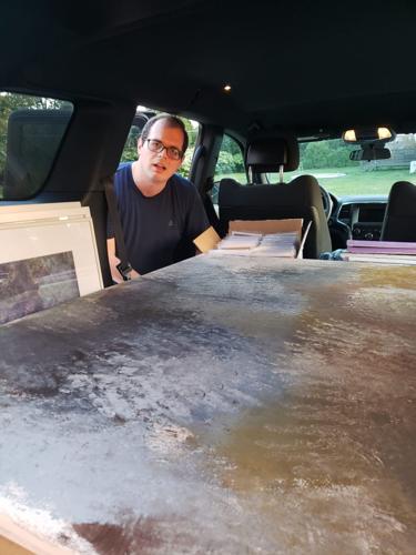Tommy Hennigan packing the car with his paintings for display at ArtWorks for his September exhibit.
