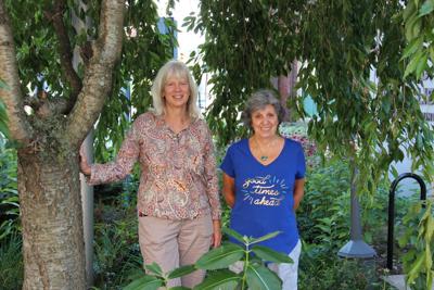 From left, Janelle Zigon and Ann Marie Warren stand in the Carbondale Public Library garden they continue to maintain and grow.
