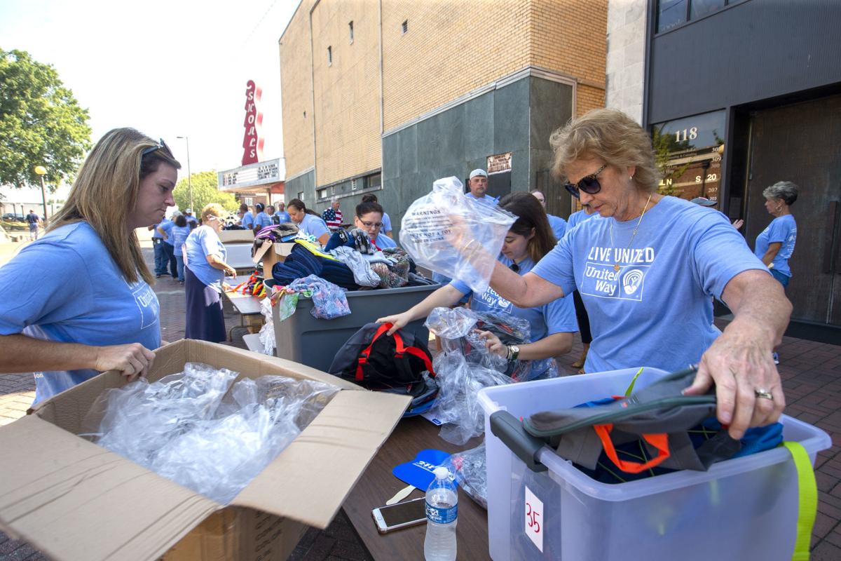 United Way Volunteers Fill Backpacks With Items For The Winter To