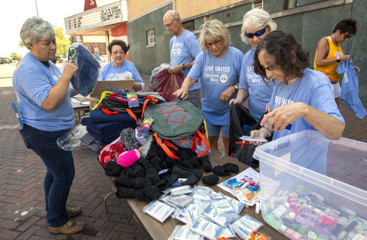 United Way Volunteers Fill Backpacks With Items For The Winter To