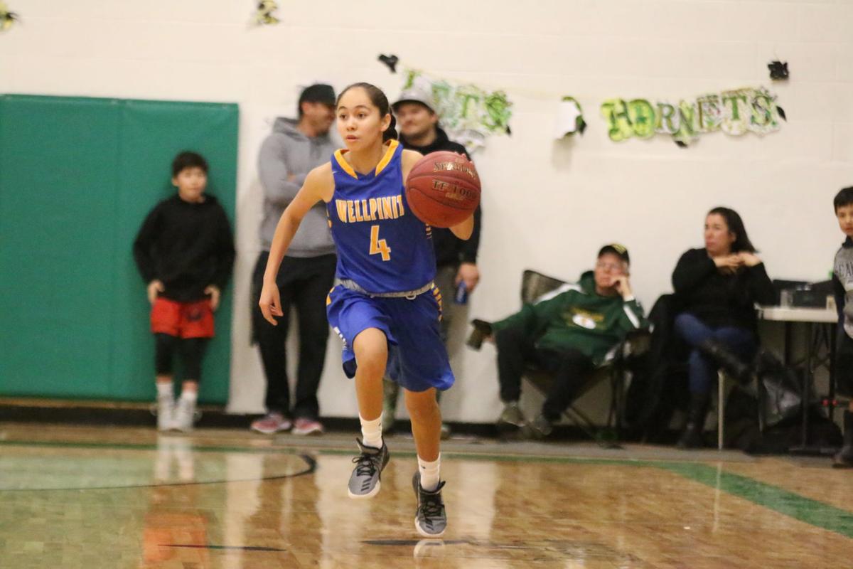 Colville tribal member Ashlynn Hill (No. 4 blue) of Wellpinit dribbles the ball up court against Inchelium on Wednesday, Feb 7 in first round of the Northeast District 7 1B girls basketball tournament. Inchelium defeated Wellpinit 61-58.