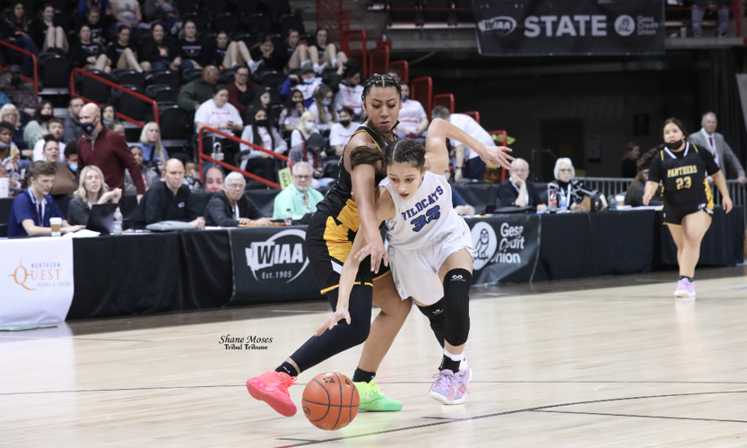 Colville tribal member Rocksie Timentwa (#32 white) of Wilbur-Creston-Keller attempts to steal the ball away against Cusick on Wednesday (March 2) evening in the opening round of this year’s WIAA 1B girls state tournament at the Spokane Arena.
