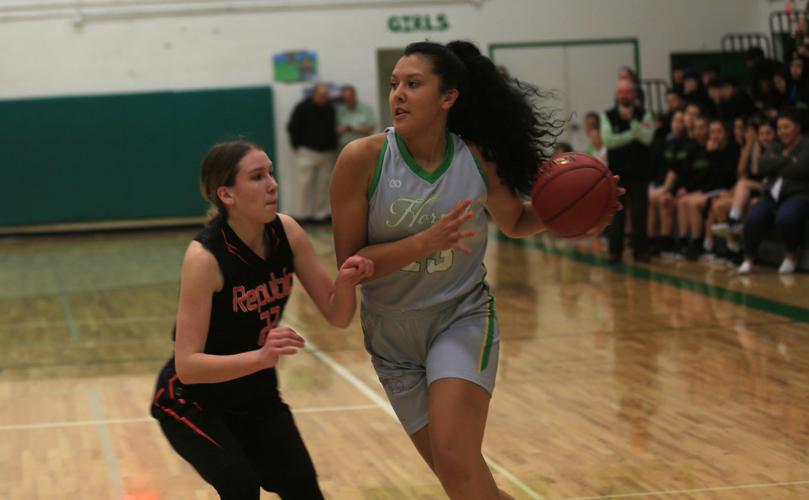 Tribal member Mia Pakootas (#13 grey) of Inchelium drives to the basket against Republic in NE 1B League action on Dec. 17.