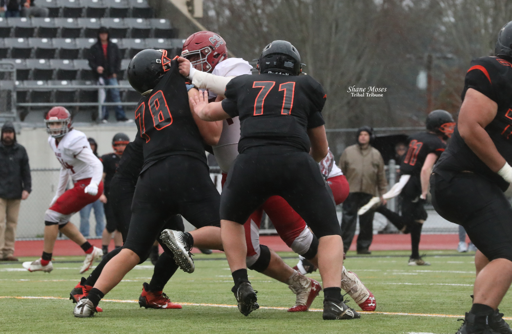 Okanogan’s James Smith #64 white (Colville tribal member) rushes the Napavine quarterback on Saturday (Nov. 27) afternoon in the semifinals of the WIAA 2B State football tournament at Tumwater District Stadium.