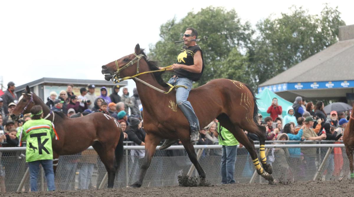 Colville tribal member Oliver Pakootas, jockey for Grizzly Mountain gets ready to leap off his horse and on to another during the first consolation race on Sunday afternoon at the third annual Muckleshoot Gold Cup at Emerald Downs racetrack in Auburn