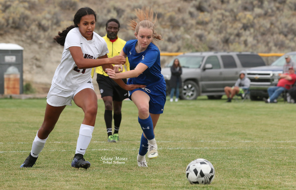 Colville tribal member Sydney Sparks (#21 white) of Okanogan fights for position to get to the ball against Tonasket on Wednesday (Sept. 22) evening in CW2B League action.
