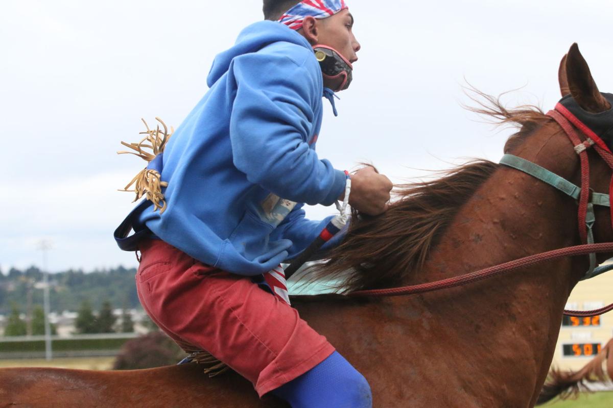 Colville tribal member Matthew Pakootas Jr., jockey for Northwest Express rides in front of the grand stand on his way to the next exchange during the second consolation race on Sunday afternoon at the third annual Muckleshoot Gold Cup at Emerald Downs racetrack in Auburn