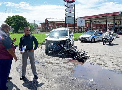 Police vehicle totaled, as driver flees after red-light violation