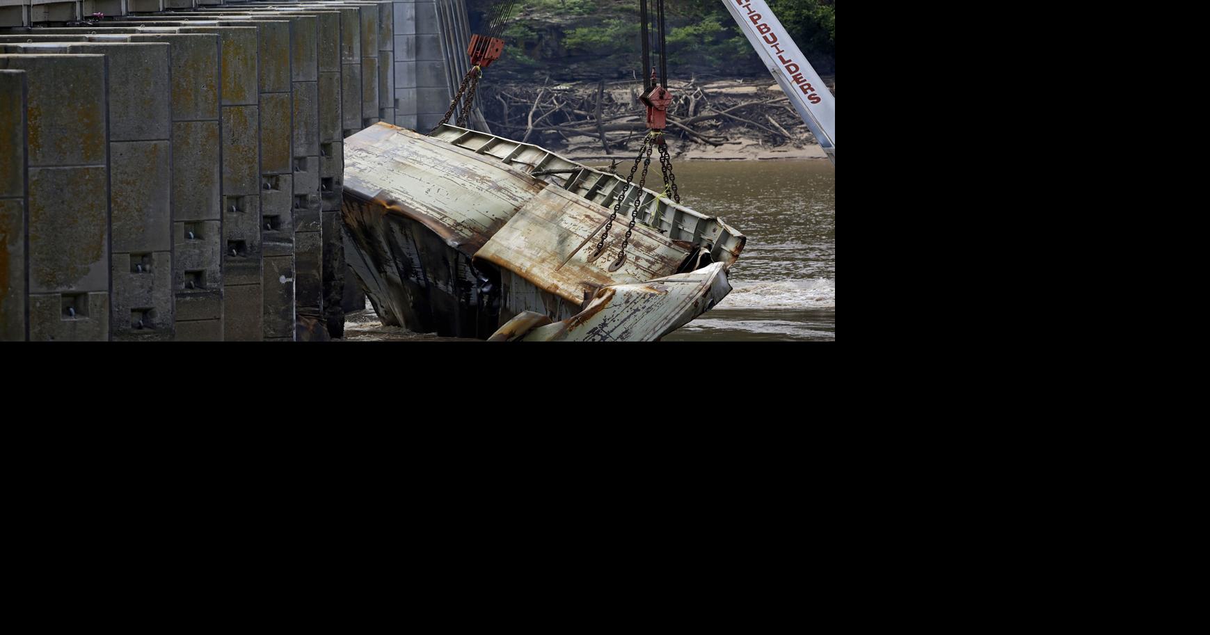 One of two crumpled barges is lifted away from bers Falls dam