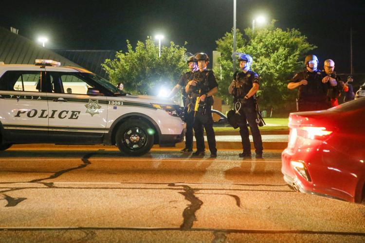 Tulsa Police Department stand nearby during protest