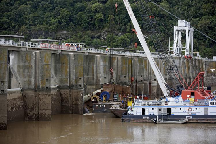 One of two crumpled barges is lifted away from bers Falls dam