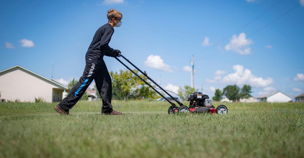 Reagan shows how to mow safely.