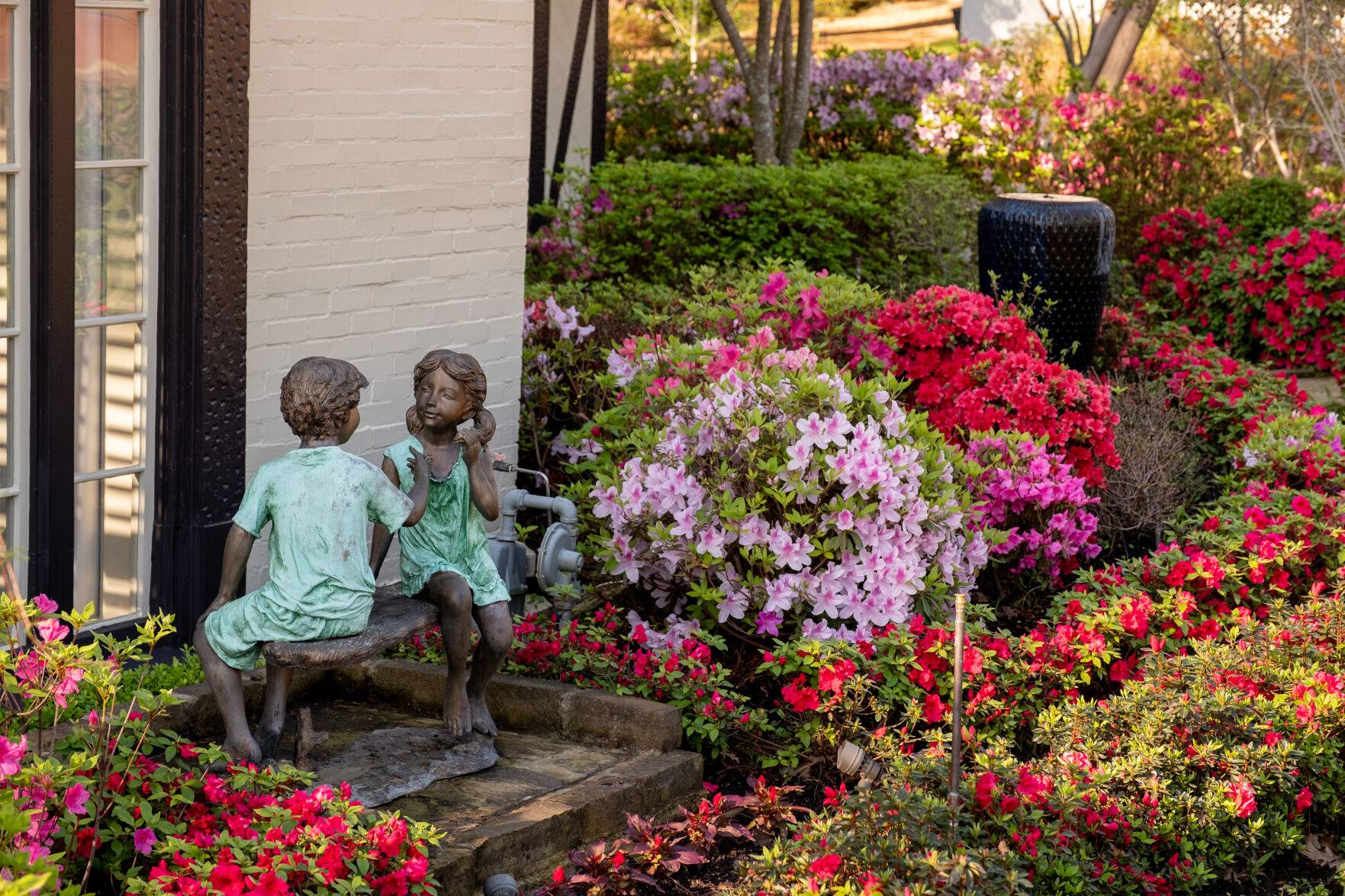 Image of Pink Raggedy Ann doll in front of flower bush