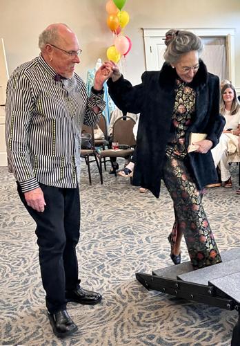 1b Geraine's son Jim Hansen assists model Elizabeth Harris Matschukat as she steps up to the runway.jpg
