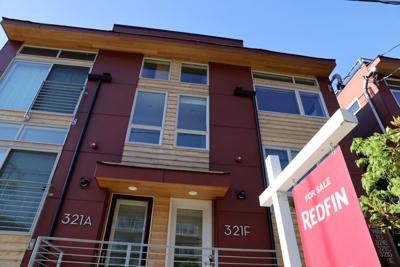 FILE PHOTO: A "For Sale" sign is posted outside a residential home in Seattle