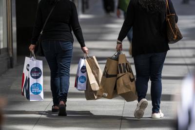 Pedestrians carry shopping bags