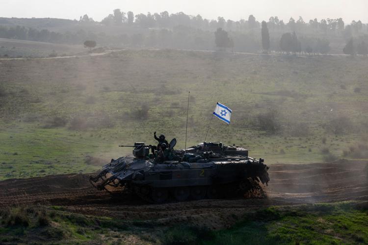 Israeli soldiers ride in an armoured personnel carrier (APC), after a temporary truce between Israel and the Palestinian Islamist group Hamas expired