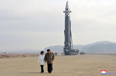 North Korean leader Kim Jong Un, along with his daughter, walks away from an ICBM in this undated photo released by KCNA