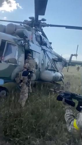 Ukraine intelligence officers inspect a Russian helicopter handed over to Ukraine by Russian pilot Maxim Kuzminov
