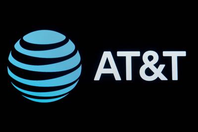 FILE PHOTO: The company logo for AT&T is displayed on a screen on the floor at the NYSE in New York